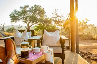 a patio with two chairs and a table with cups at Baobab Hill House by RETURN Africa in Makuleke Contract Park