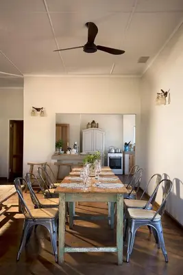 a dining room with a wooden table and chairs at Baobab Hill House by RETURN Africa in Makuleke Contract Park