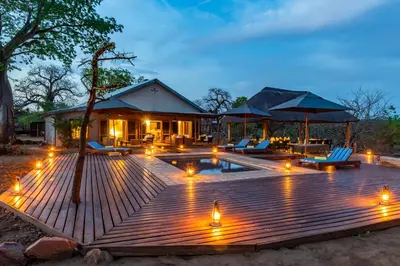 a wooden deck with lights in front of a house at Baobab Hill House by RETURN Africa in Makuleke Contract Park