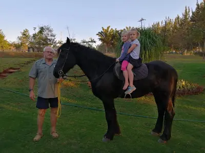 a man and a little girl sitting on a horse at Eden Cottage in White River