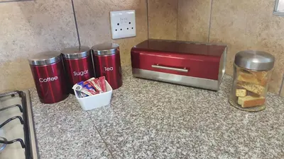 a red toaster and two trash cans on a counter at Eden Cottage in White River