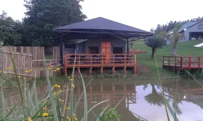 a house with a gazebo next to a pond at Eden Cottage in White River