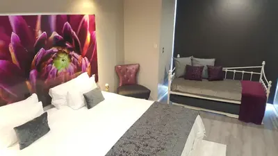 a bedroom with a bed with a flower mural on the wall at Chill Pepper Boutique Hotel in Nelspruit