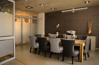 a dining room with a wooden table and chairs at Chill Pepper Boutique Hotel in Nelspruit