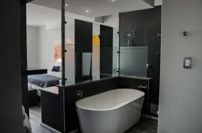 a bathroom with a bath tub and a mirror at Chill Pepper Boutique Hotel in Nelspruit