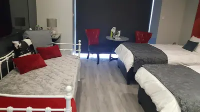 a hotel room with two beds and a table with a table at Chill Pepper Boutique Hotel in Nelspruit