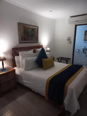a bedroom with a large white bed with pillows at J'Cups Guest House in Centurion