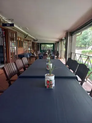 a long table with a blue table cloth and a plant on it at J'Cups Guest House in Centurion