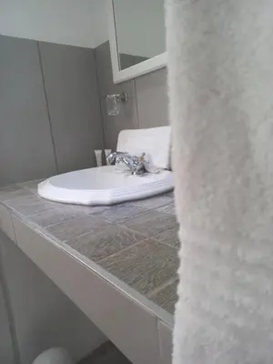 a bathroom with a white sink and a mirror at J'Cups Guest House in Centurion