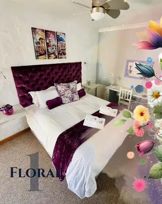 a bedroom with a large bed with a purple headboard at Longtom Farm Guesthouse in Lydenburg