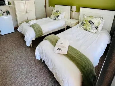 a room with two beds with towels on them at Longtom Farm Guesthouse in Lydenburg