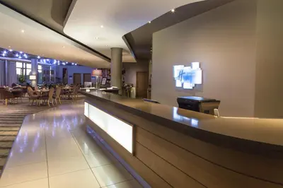 a bar in a restaurant with tables and chairs at Holiday Inn Express Sandton-Woodmead by IHG in Johannesburg