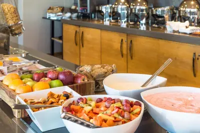 a buffet with bowls of fruit and a bowl of dip at Holiday Inn Express Sandton-Woodmead by IHG in Johannesburg