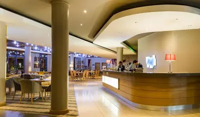 a restaurant with a bar and tables and chairs at Holiday Inn Express Sandton-Woodmead by IHG in Johannesburg