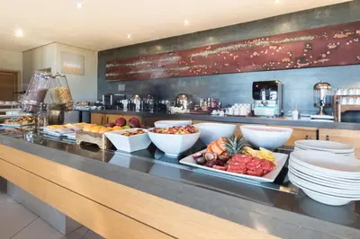 a buffet line with plates and bowls of food at Holiday Inn Express Sandton-Woodmead by IHG in Johannesburg