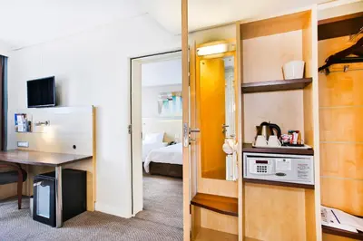 a small room with a bed and a room with a desk at Holiday Inn Express Sandton-Woodmead by IHG in Johannesburg