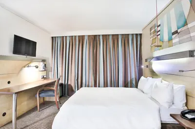 a hotel room with a large bed and a desk at Holiday Inn Express Sandton-Woodmead by IHG in Johannesburg
