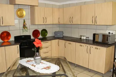 a kitchen with a vase with a flower on a table at Tarentilos in Tzaneen