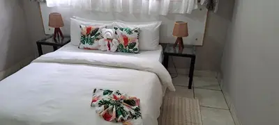 a bed with two pillows on it with two lamps at Tarentilos in Tzaneen