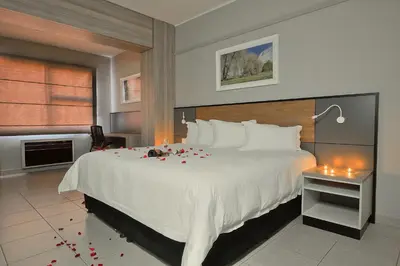 a bedroom with a large bed with roses on it at The Park Lodge Hotel in Pretoria