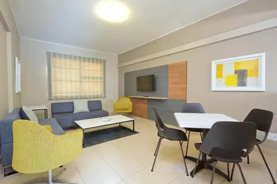 a living room with a couch and a table and chairs at The Park Lodge Hotel in Pretoria