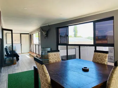a dining room with a wooden table and chairs at Nelspruit Lodge in Nelspruit