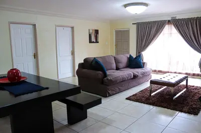 a living room with a couch and a table at Blue Sparrow Guest House in Middelburg