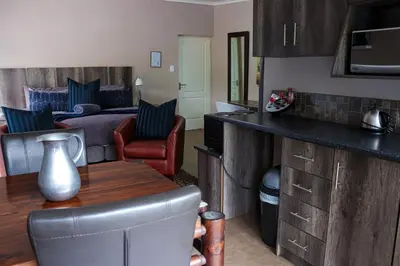 a kitchen and living room with a bed and a table at Blue Sparrow Guest House in Middelburg