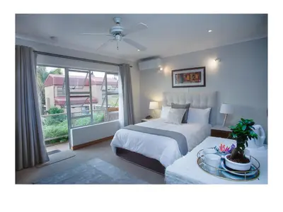 a bedroom with a bed and a large window at The Monte Carlo in Centurion