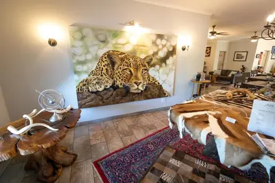 a room with a painting of a jaguar on the wall at The Belgium Inn in Hoedspruit