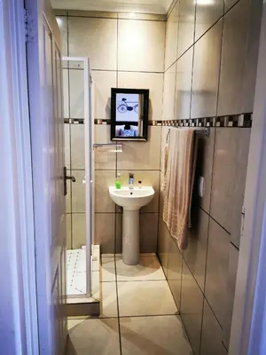a small bathroom with a sink and a shower at Guest House Mamma Mia in Nelspruit