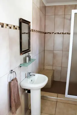 a bathroom with a sink and a mirror at Guest House Mamma Mia in Nelspruit