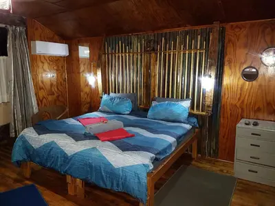 a bedroom with a bed with blue sheets and blue pillows at Thandamanzi Self Catering in Sabie