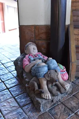 a little girl laying on a statue of a child at The Cedars Bed and Breakfast in Centurion