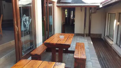 a wooden table and benches on a patio at The Cedars Bed and Breakfast in Centurion