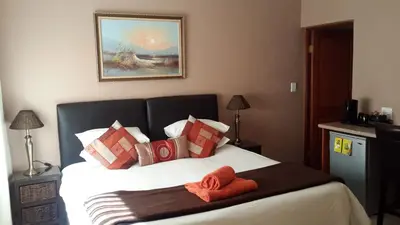 a bedroom with a bed with two towels on it at The Cedars Bed and Breakfast in Centurion