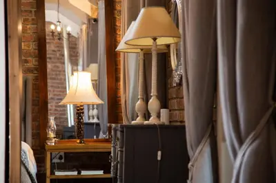 a living room with a lamp and a mirror at Tarry-Stone Cottages in Dullstroom