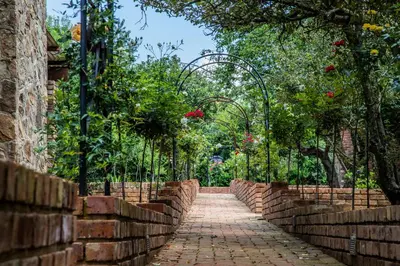 a brick path with a garden in the background at Tarry-Stone Cottages in Dullstroom