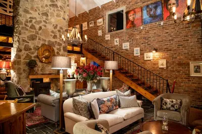 a living room with two couches and a staircase at Tarry-Stone Cottages in Dullstroom