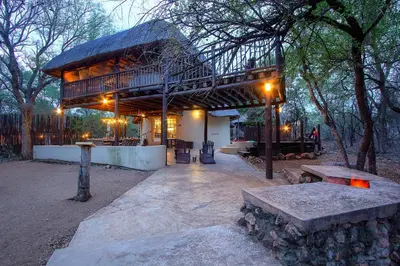 a pavilion with benches in a park at night at Treetops Marloth Park in Marloth Park