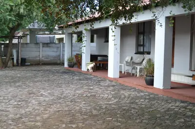 a courtyard of a house with chairs and a table at Komati Friends in Komatipoort