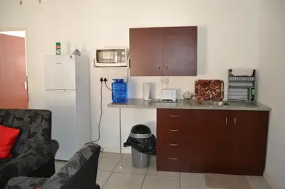 a kitchen with a counter with a sink and a refrigerator at Komati Friends in Komatipoort