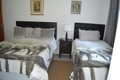 a bedroom with two beds and a night stand at Komati Friends in Komatipoort