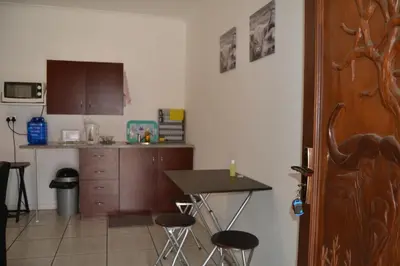 a kitchen with a table and some stools in it at Komati Friends in Komatipoort