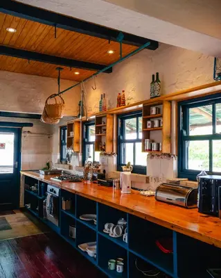 a kitchen with blue cabinets and a wooden counter top at Anglers Court in Dullstroom