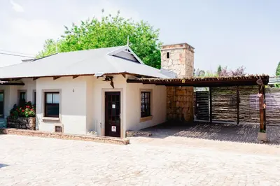 a small white building with a roof at Anglers Court in Dullstroom