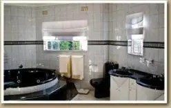 a bathroom with a tub and a toilet and a sink at Gannet Place Guest House in Hazyview