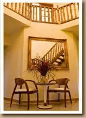 a room with a table and two chairs and a mirror at Gannet Place Guest House in Hazyview