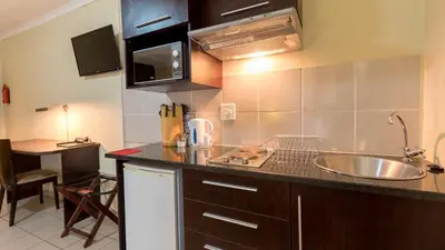 a kitchen with a sink and a counter top at Gannet Place Guest House in Hazyview