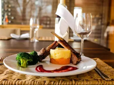 a plate of food with meat and broccoli on a table at Honeyguide Tented Safari Camps - Mantobeni in Manyeleti Game Reserve